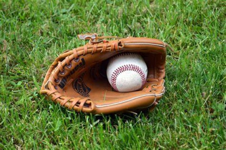Baseball mitt with ball in grass